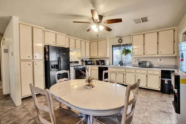 kitchen featuring light tile patterned floors, cream cabinetry, ceiling fan, black appliances, and sink