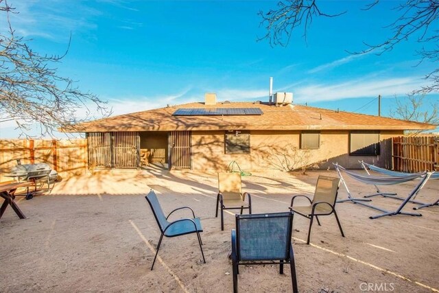 back of house with a patio area and solar panels