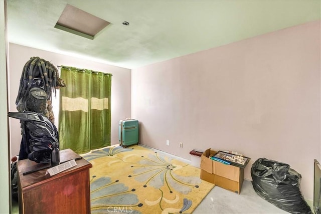 interior space featuring attic access and concrete flooring