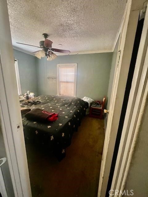 bedroom with ceiling fan, a textured ceiling, and ornamental molding