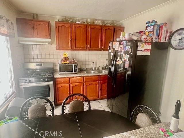 kitchen with light tile patterned flooring, stainless steel appliances, a healthy amount of sunlight, and sink