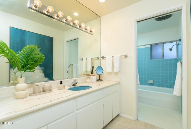 bathroom with tiled shower / bath combo and vanity