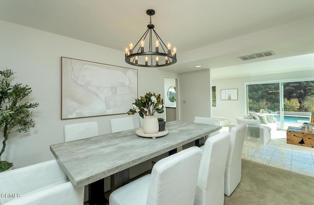 dining area featuring light colored carpet and a chandelier