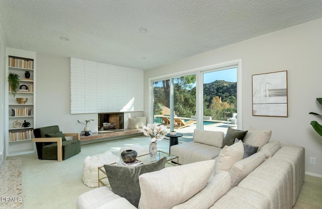 living room with a textured ceiling, light carpet, and a fireplace