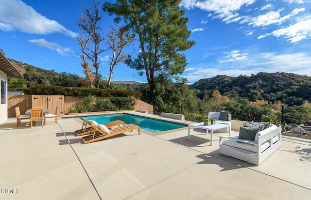 view of swimming pool featuring a mountain view, an outdoor living space, and a patio