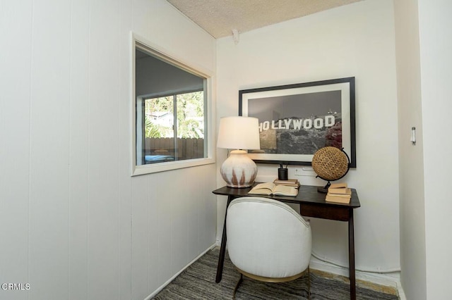 office space with a textured ceiling and wood walls