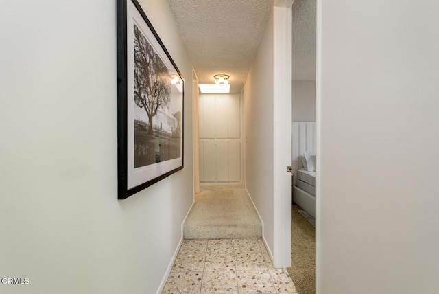 hall featuring a textured ceiling