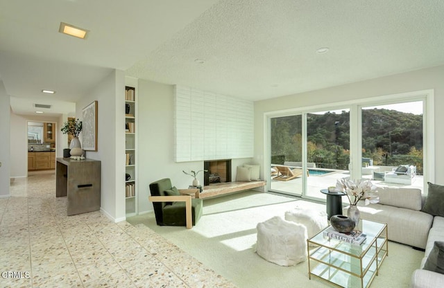 living room featuring a textured ceiling and a large fireplace