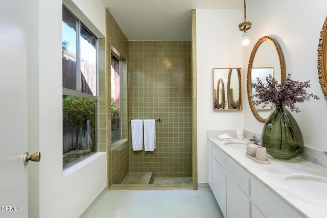 bathroom with vanity and a tile shower