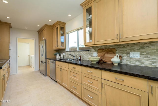 kitchen featuring backsplash, sink, dark stone countertops, and stainless steel appliances