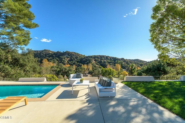 view of swimming pool with an outdoor living space, a mountain view, a yard, and a patio