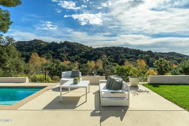 view of swimming pool with a mountain view, outdoor lounge area, and a patio