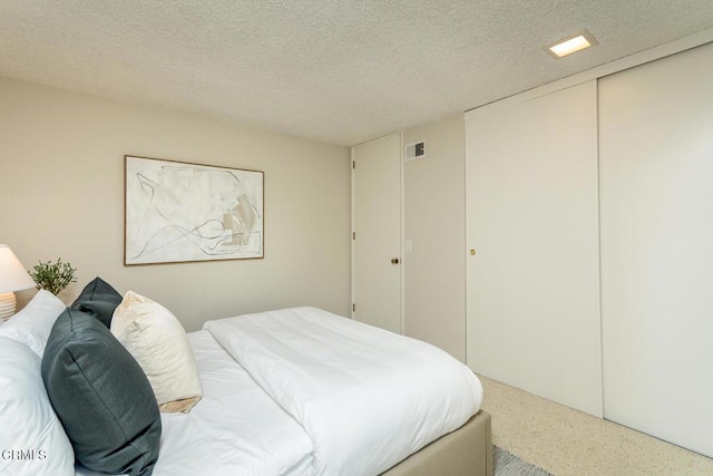 bedroom with a textured ceiling and a closet