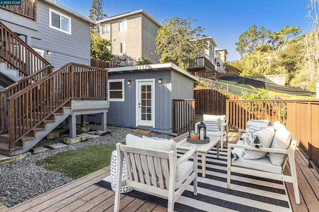 wooden deck featuring an outdoor living space and a storage unit