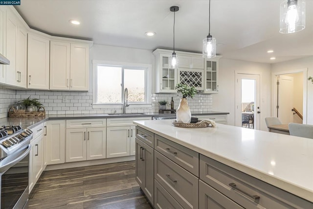 kitchen with white cabinetry, stainless steel stove, and sink