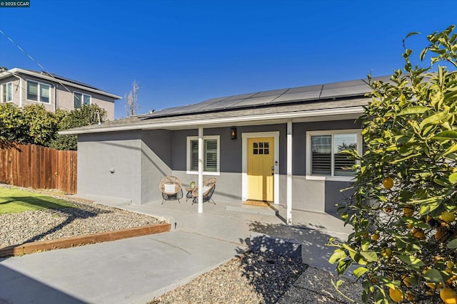 view of front of home with a porch and solar panels