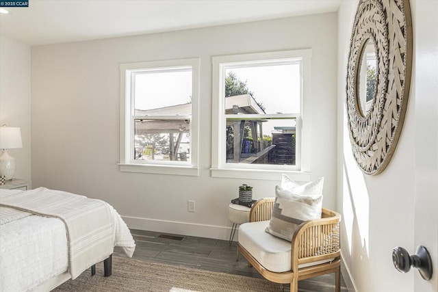 bedroom with dark wood-type flooring and multiple windows