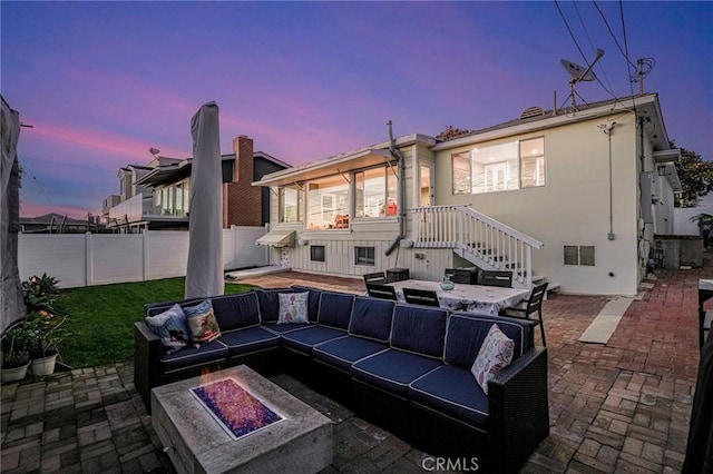 patio terrace at dusk with an outdoor living space with a fire pit