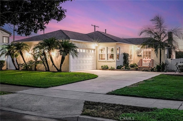 ranch-style house with a garage and a lawn