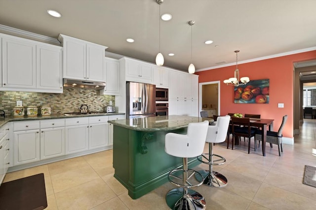 kitchen featuring decorative light fixtures, backsplash, stainless steel appliances, and a kitchen island