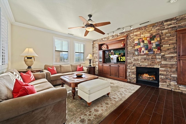 living room with ceiling fan, ornamental molding, track lighting, and a fireplace