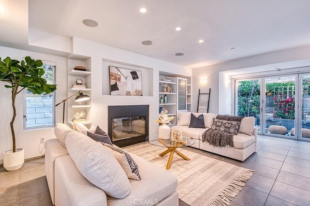 2618 Cove St, Corona Del Mar, CA 92625 - living area featuring built in shelves, tile patterned flooring, a glass covered fireplace, and recessed lighting