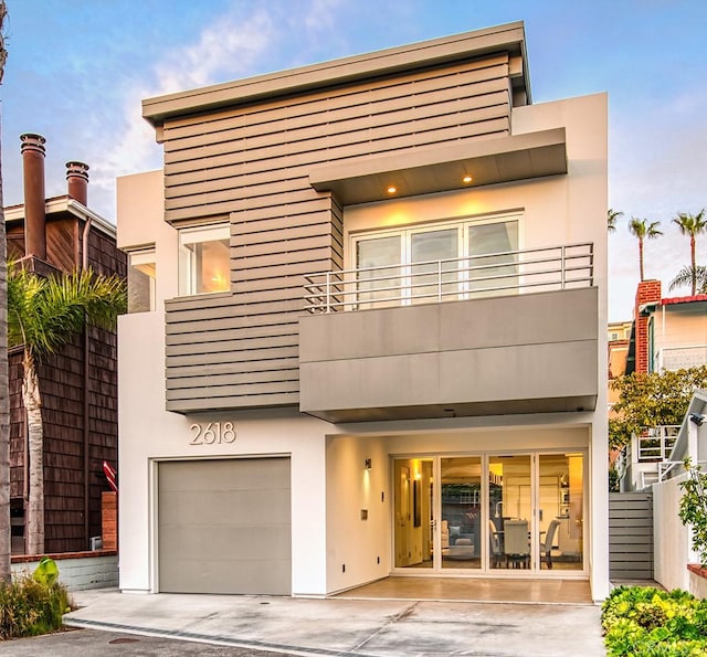 view of front facade featuring a garage and a balcony