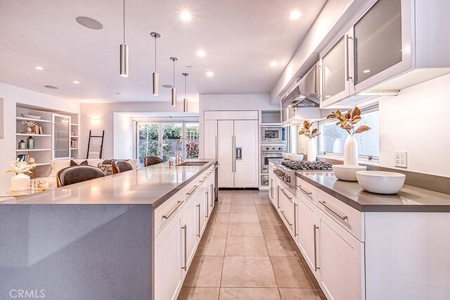 2618 Cove St, Corona Del Mar, CA 92625 - kitchen with built in appliances, white cabinets, a sink, light tile patterned floors, and a large island