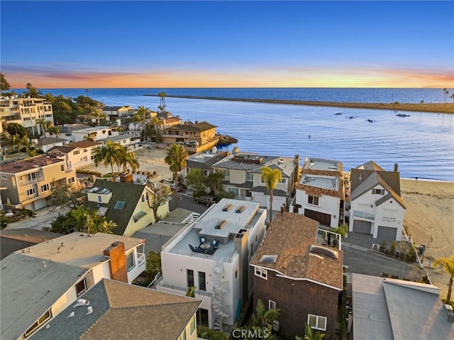 aerial view at dusk featuring a water view