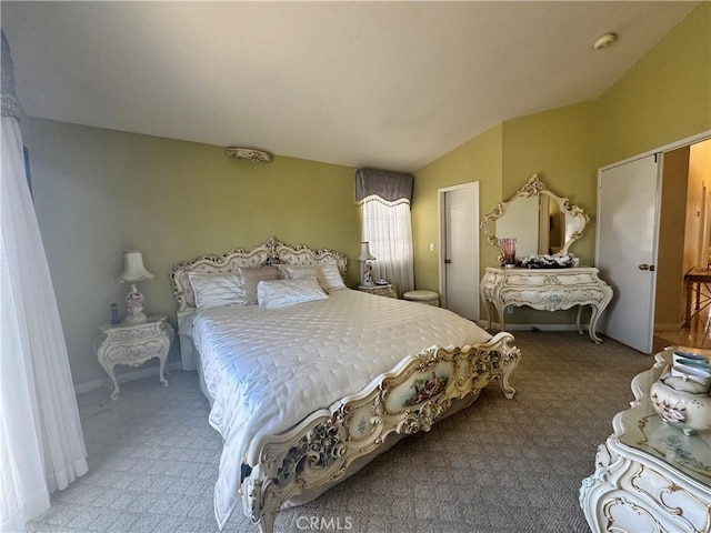 bedroom with light colored carpet and vaulted ceiling