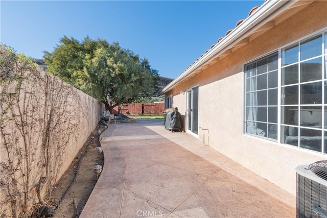 view of side of home with central AC and a patio area