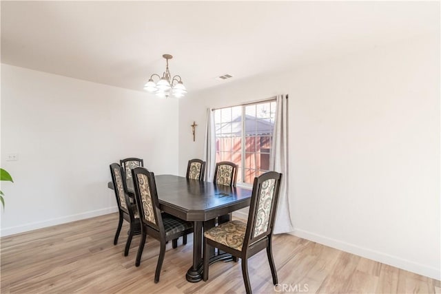 dining area with a notable chandelier and light wood-type flooring