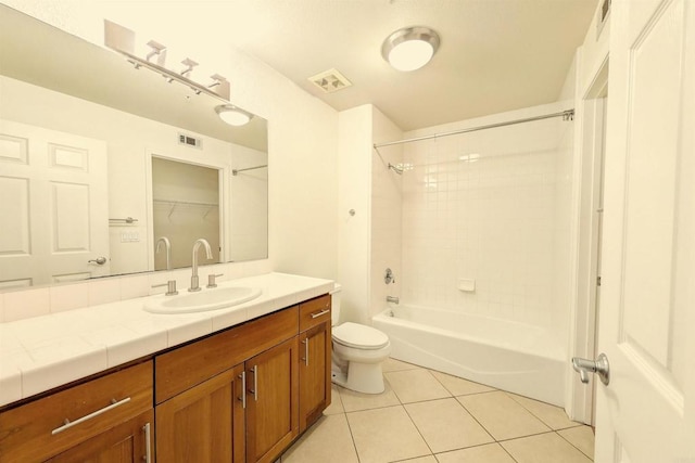 full bathroom featuring toilet, vanity, tiled shower / bath combo, and tile patterned flooring