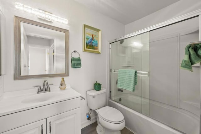 full bathroom with toilet, bath / shower combo with glass door, and vanity