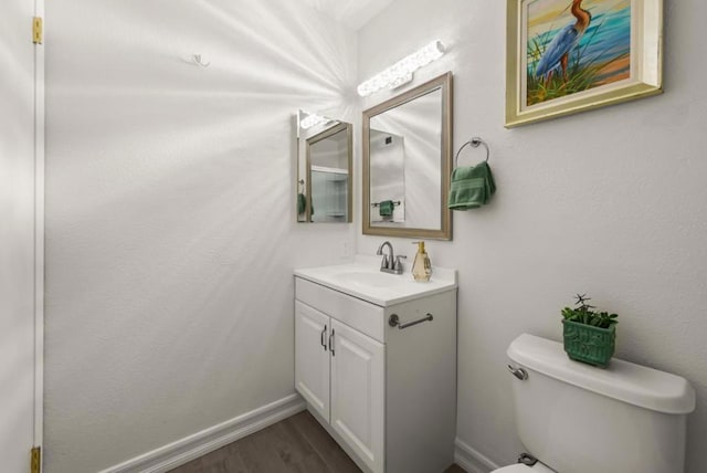 bathroom featuring toilet, wood-type flooring, and vanity