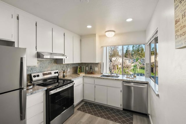 kitchen featuring decorative backsplash, sink, appliances with stainless steel finishes, white cabinets, and dark hardwood / wood-style flooring