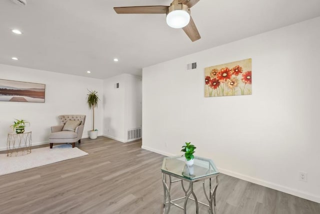 living area featuring light wood-type flooring and ceiling fan