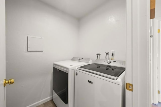 laundry room featuring separate washer and dryer and light hardwood / wood-style floors