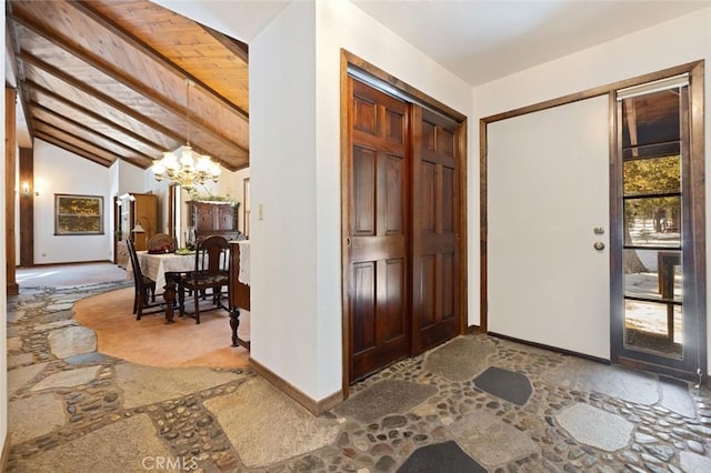 foyer with an inviting chandelier and lofted ceiling