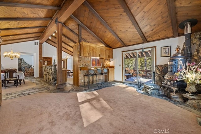 unfurnished living room with carpet, beam ceiling, a wood stove, high vaulted ceiling, and wooden ceiling