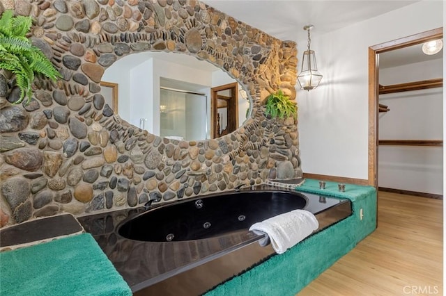 bathroom featuring wood-type flooring and a tub to relax in