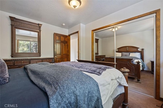 carpeted bedroom with a closet and a textured ceiling