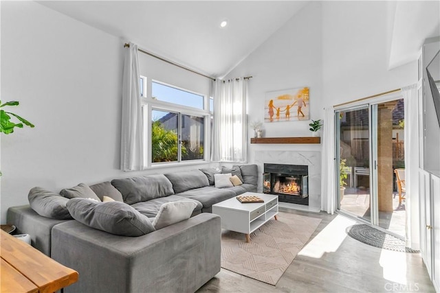 living room featuring high vaulted ceiling and a high end fireplace