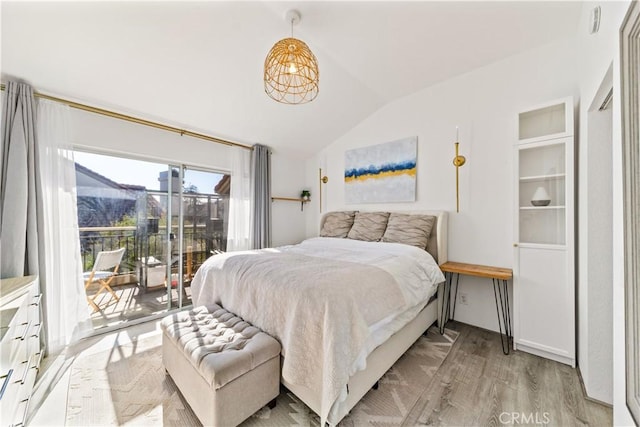 bedroom featuring access to outside, vaulted ceiling, and light hardwood / wood-style flooring