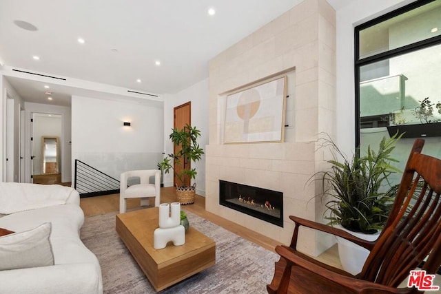 living room featuring hardwood / wood-style floors and a tiled fireplace