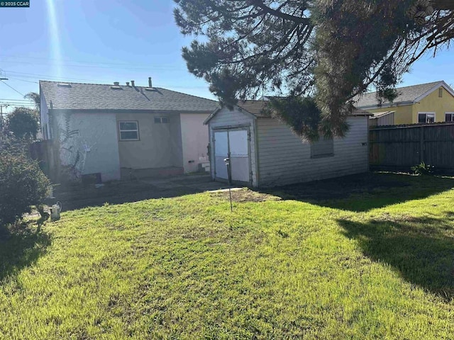 back of property with a storage shed and a yard