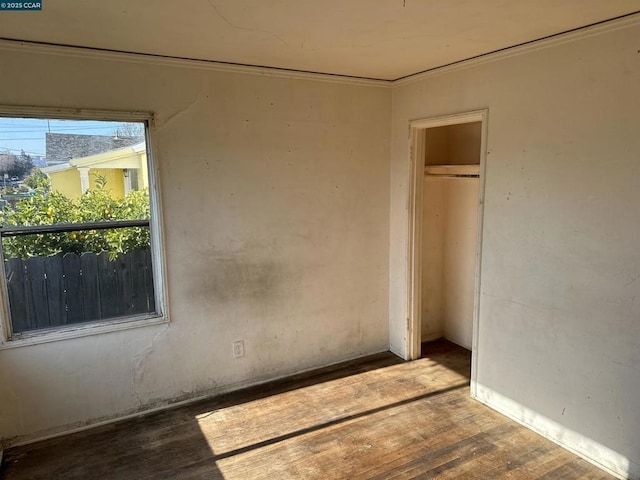 empty room with crown molding and hardwood / wood-style flooring