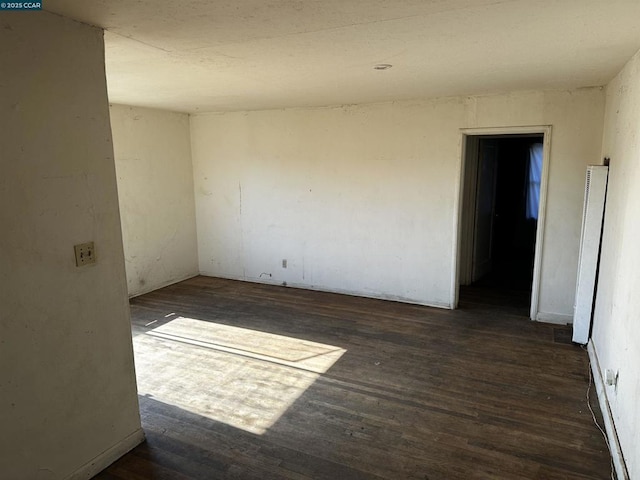 spare room with dark wood-type flooring