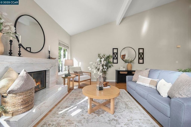 living room featuring lofted ceiling with beams, hardwood / wood-style floors, and a fireplace