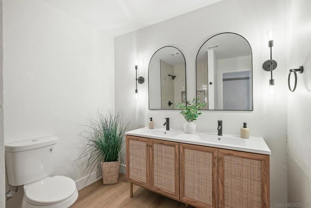 bathroom with toilet, vanity, and wood-type flooring